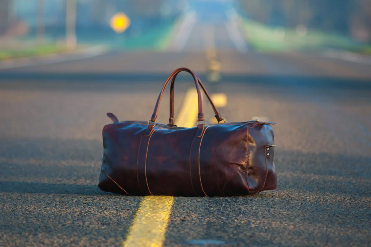 Sac en cuir posé au milieu d’une route