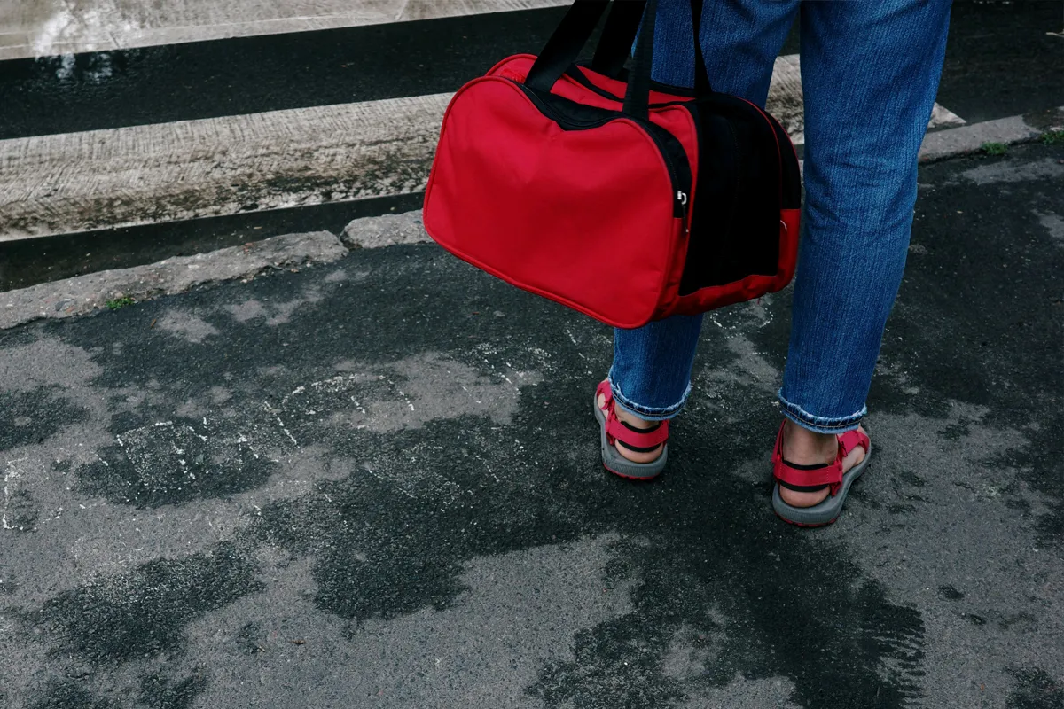 Voyageur portant un petit sac rouge à la main