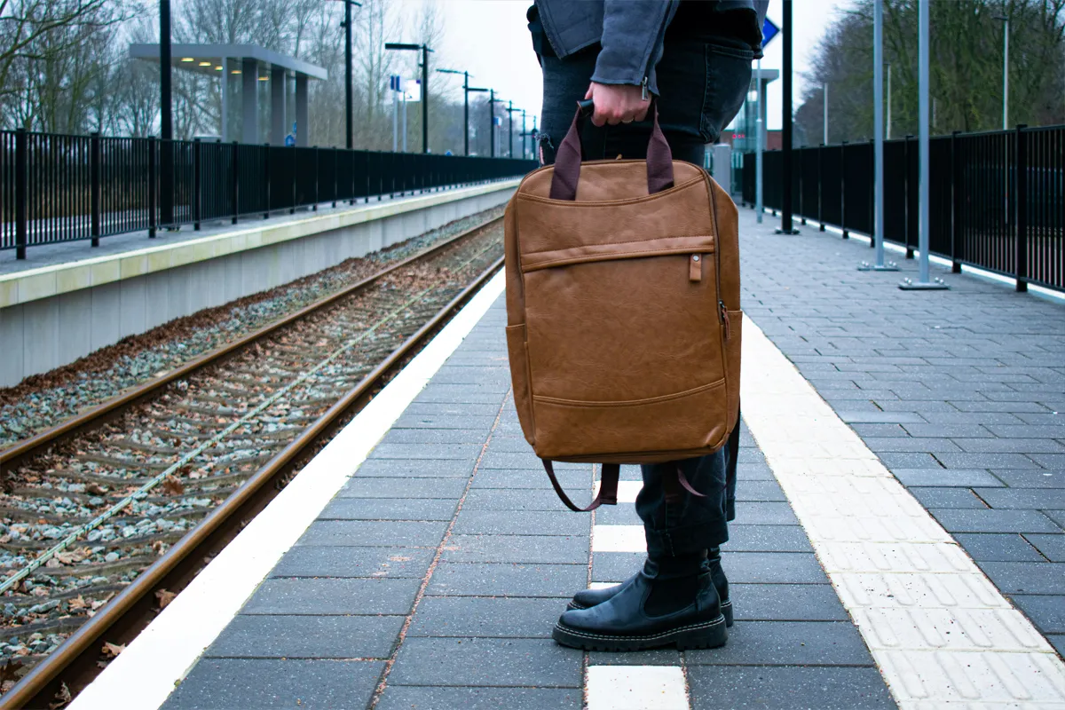 Voyageur avec un sac brun sur un quai de gare